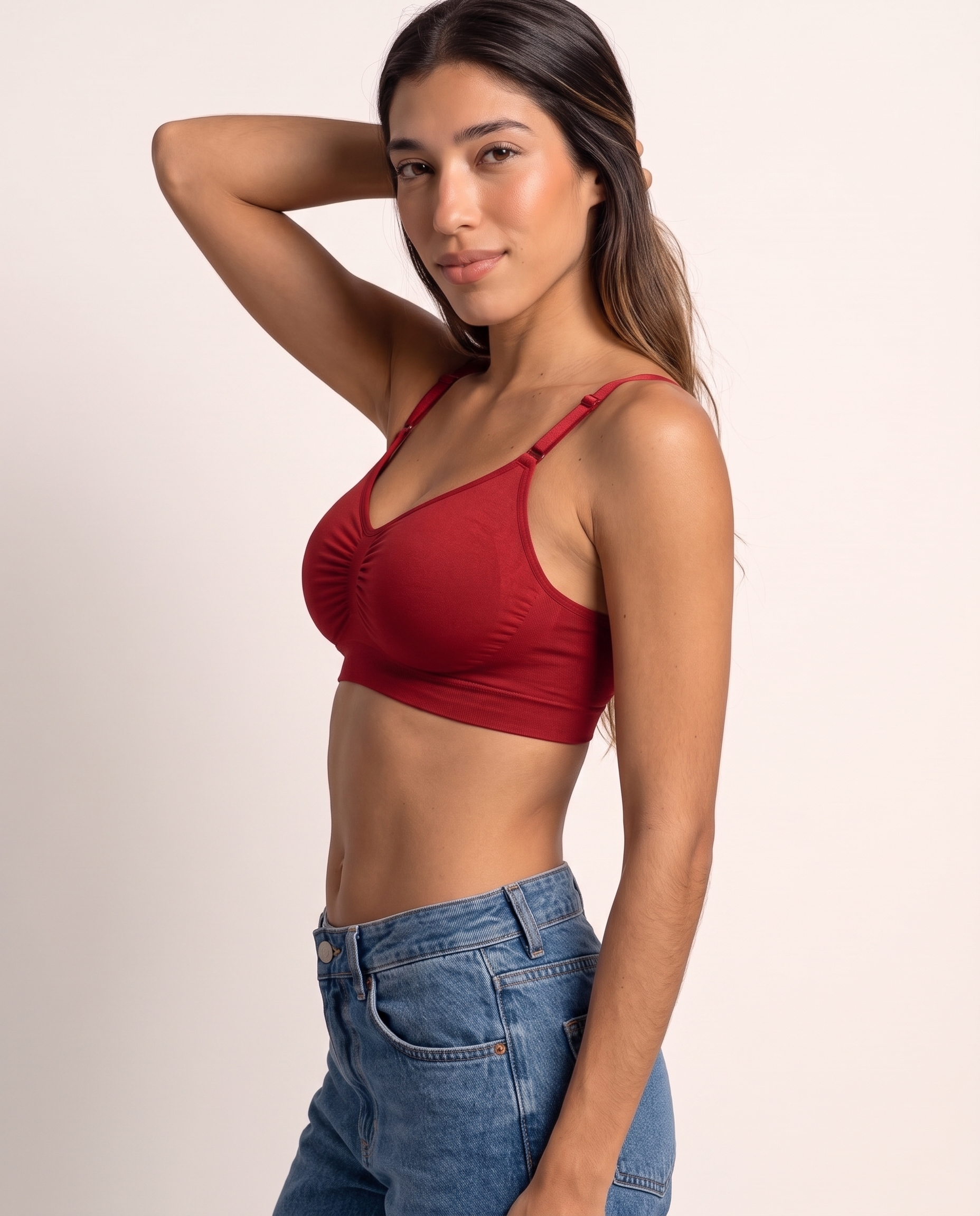 Model in a side pose with hand behind head, wearing the Wireless Shaping Bra in red