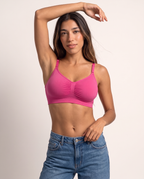 Model with one arm raised in the Wireless Shaping Bra in hot pink