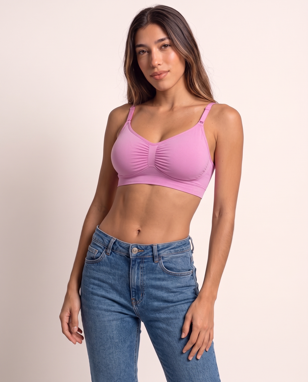 Model leaning in a relaxed pose in the Wireless Shaping Bra in candy pink