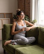 Model relaxing on a green couch in the gray Ribbed Lounge Wide-Leg Pants