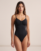 Model wearing the full coverage One & Done Shaping Bodysuit in black