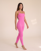 Model turning mid-movement in the Bra-Free Shaping Jumpsuit in Blush Pink.