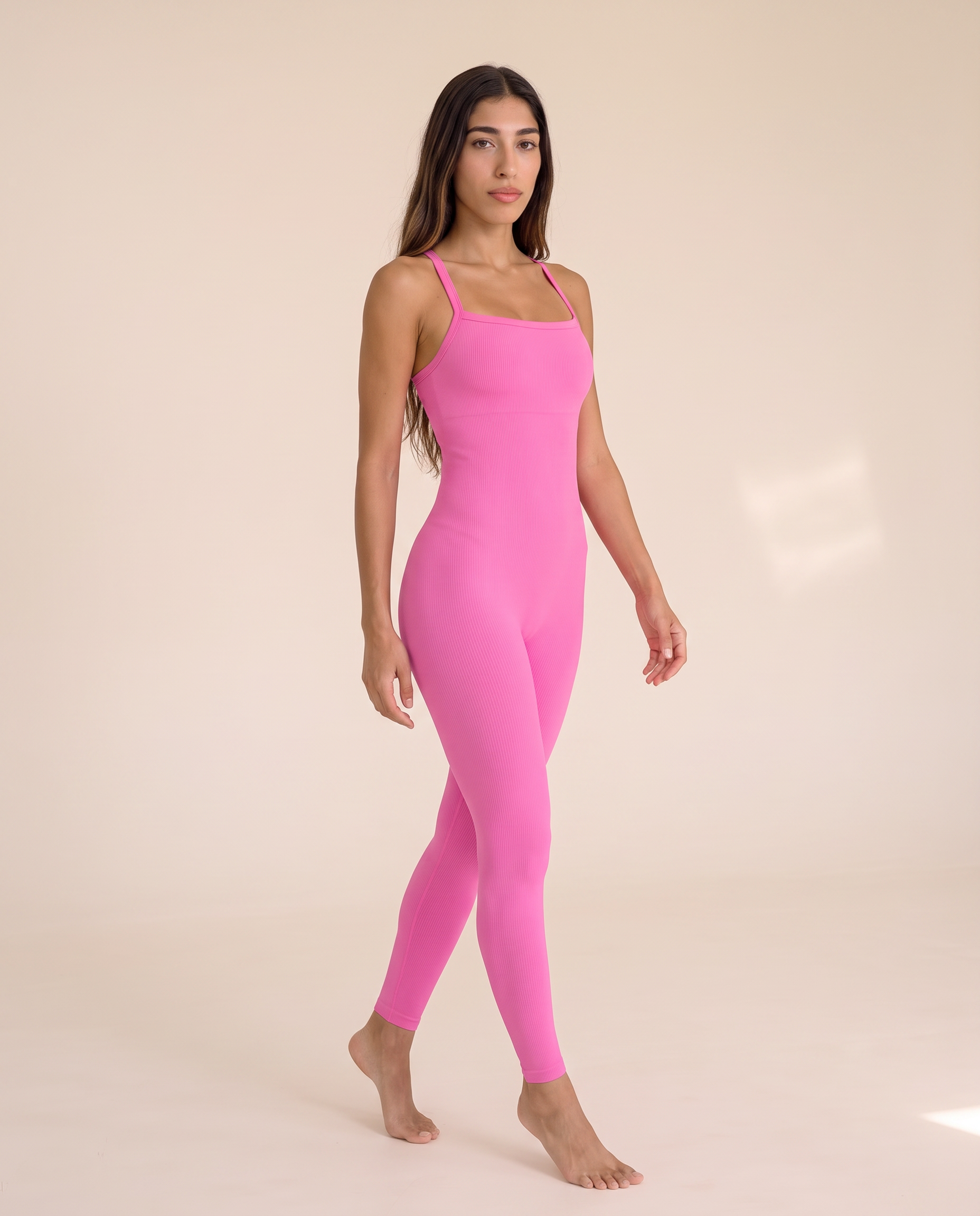 Model turning mid-movement in the Bra-Free Shaping Jumpsuit in Blush Pink.