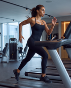 Model sprinting on a treadmill in the Bra-Free Shaping Jumpsuit in Black.