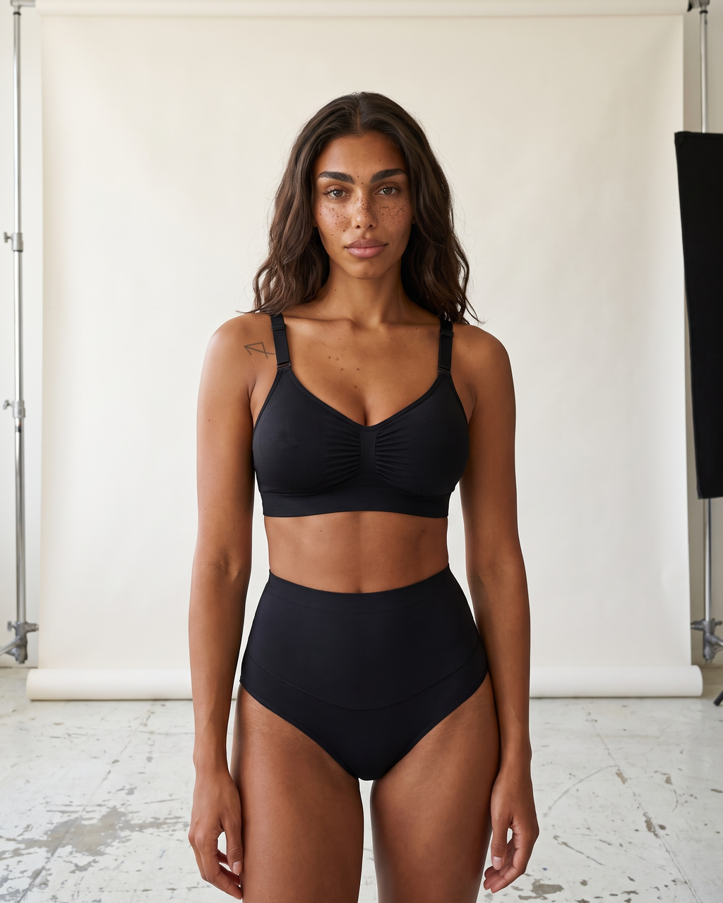 No-Show Tummy Control Thong in Black — straight-on front view in studio.