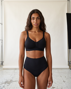 No-Show Tummy Control Thong in Black — straight-on front view in studio.