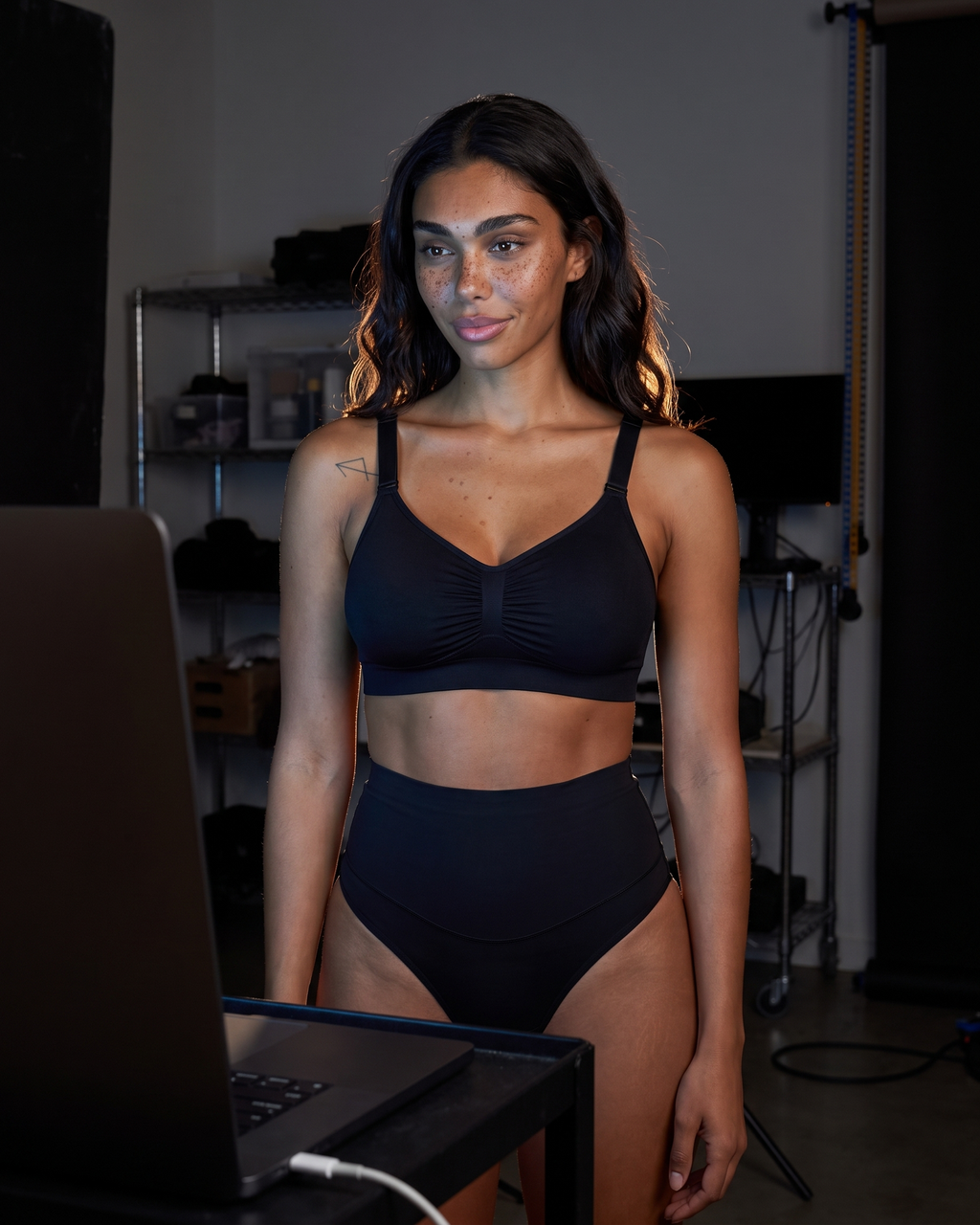 No-Show Tummy Control Thong in Black — in a dim laptop-lit room.