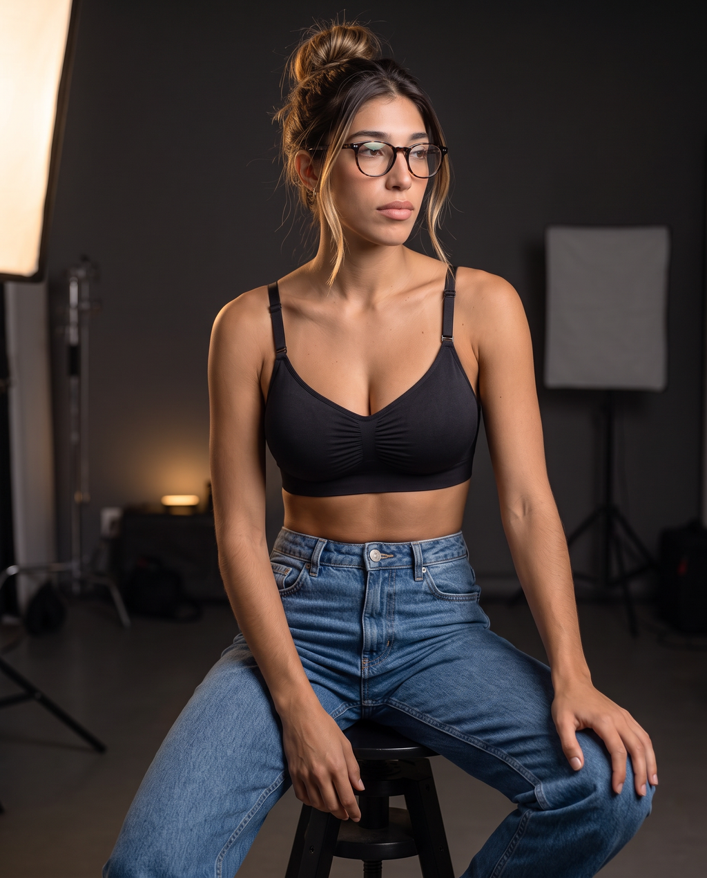 Model in glasses seated on a stool wearing the Wireless Shaping Bra in black